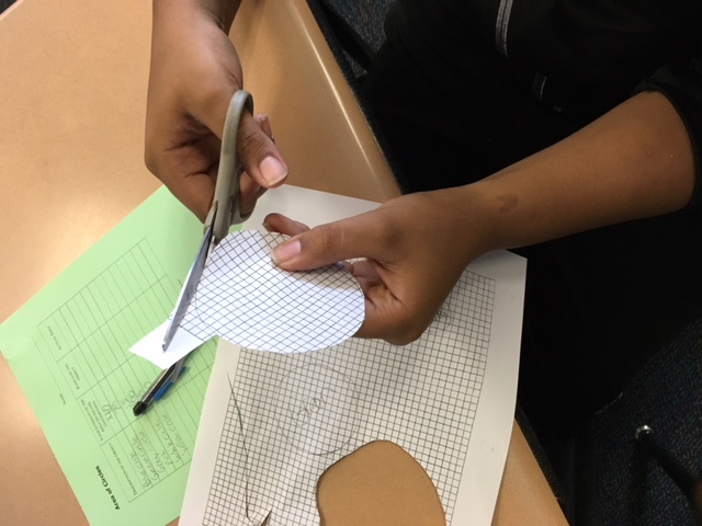 student cutting a paper circle